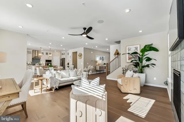 a kitchen with stainless steel appliances granite countertop a stove a kitchen island a refrigerator and couches