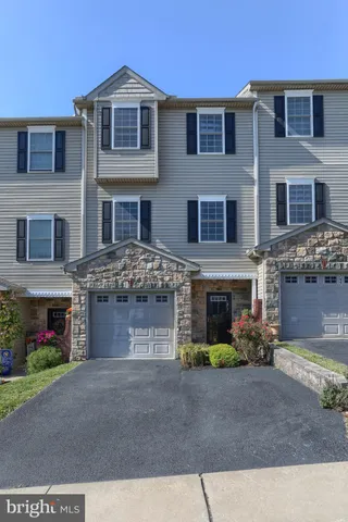 a front view of a house with garden and parking