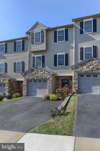 a front view of a house with yard and parking