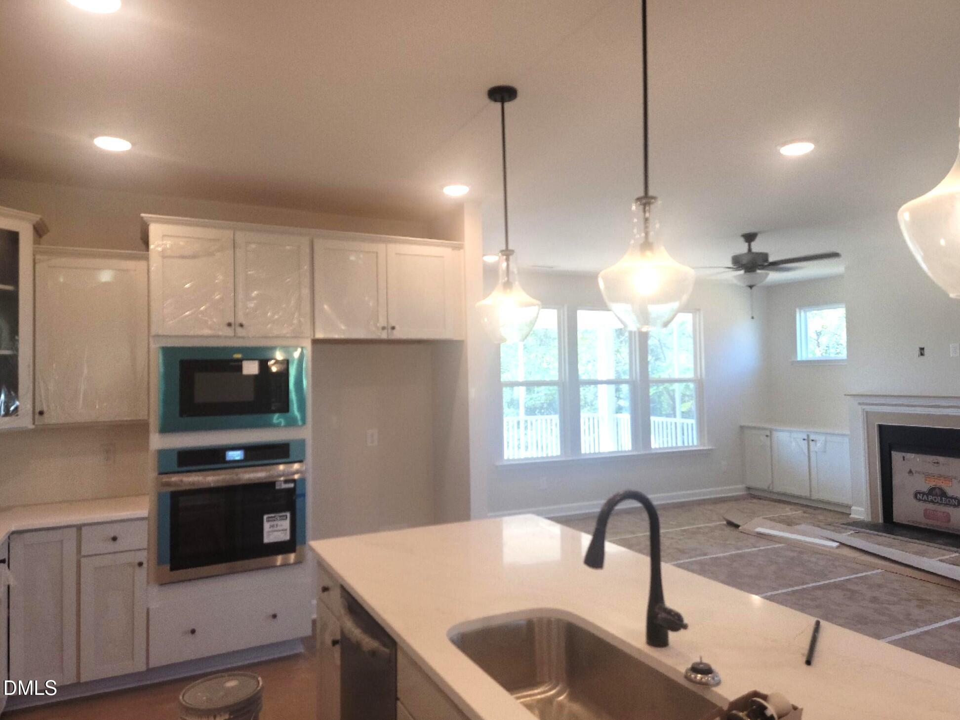 409 Grading Stick Court Angier, NC 27501 - Photo 42 of 52 a kitchen with kitchen island a sink appliances and a counter top space