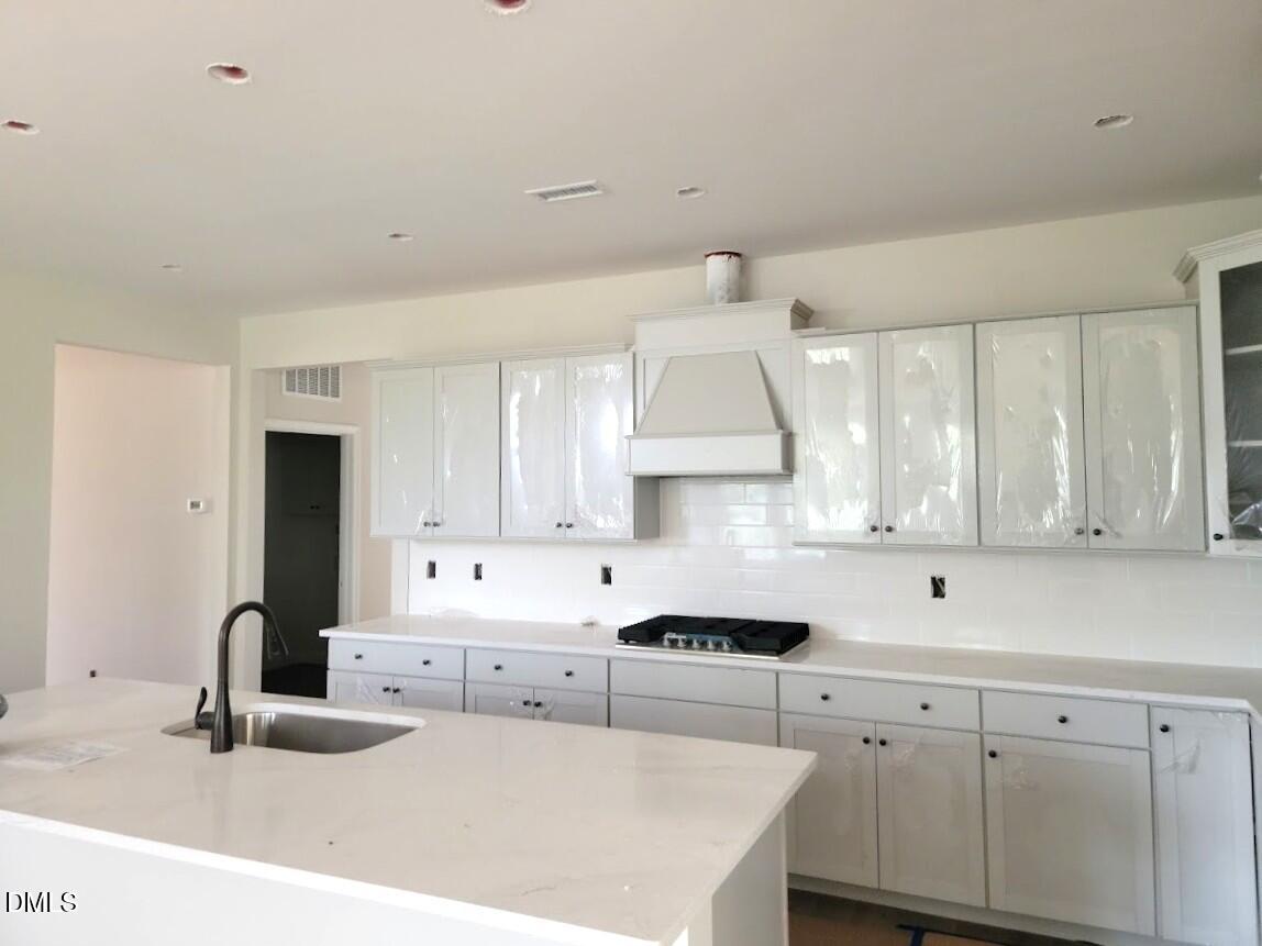 409 Grading Stick Court Angier, NC 27501 - Photo 43 of 52 a kitchen with kitchen island granite countertop a sink a stove and cabinets