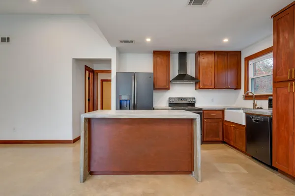 a kitchen with stainless steel appliances granite countertop a stove a sink and a refrigerator