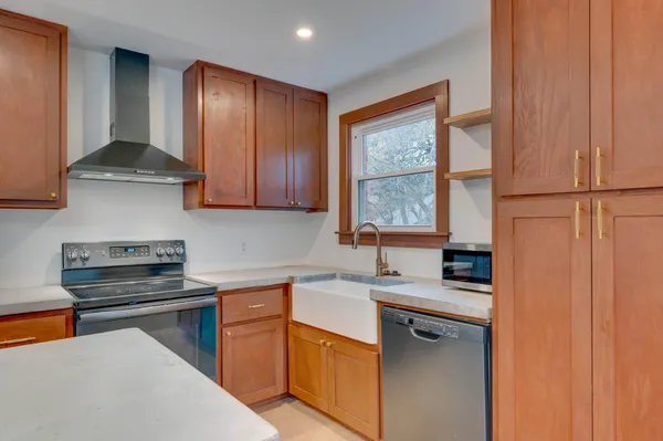 a kitchen with stainless steel appliances granite countertop a sink stove and cabinets