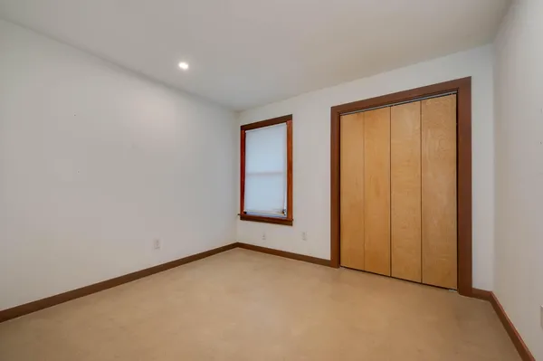 an empty room with windows and closet