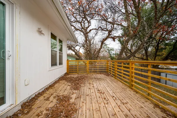 a view of a balcony with wooden floor and fence