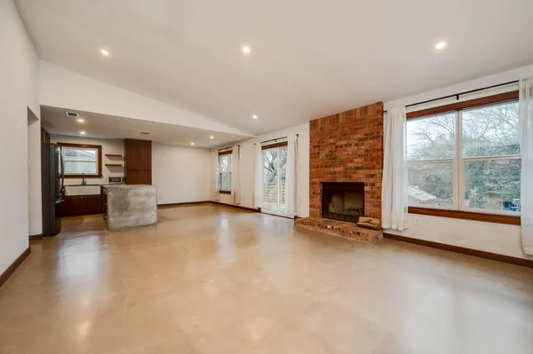 an empty room with fireplace and windows