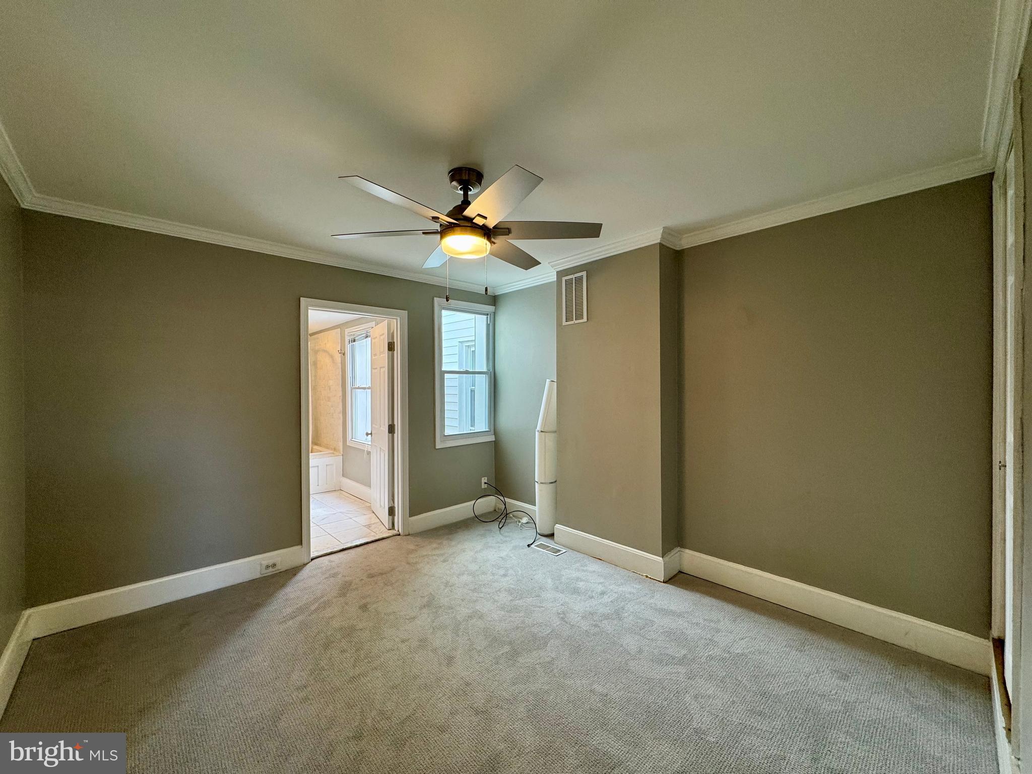 1313 Patapsco Street Baltimore, MD 21230 - Photo 13 of 20 an empty room with a chandelier fan and windows
