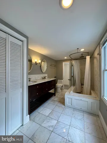 a bathroom with a double vanity sink mirror and shower