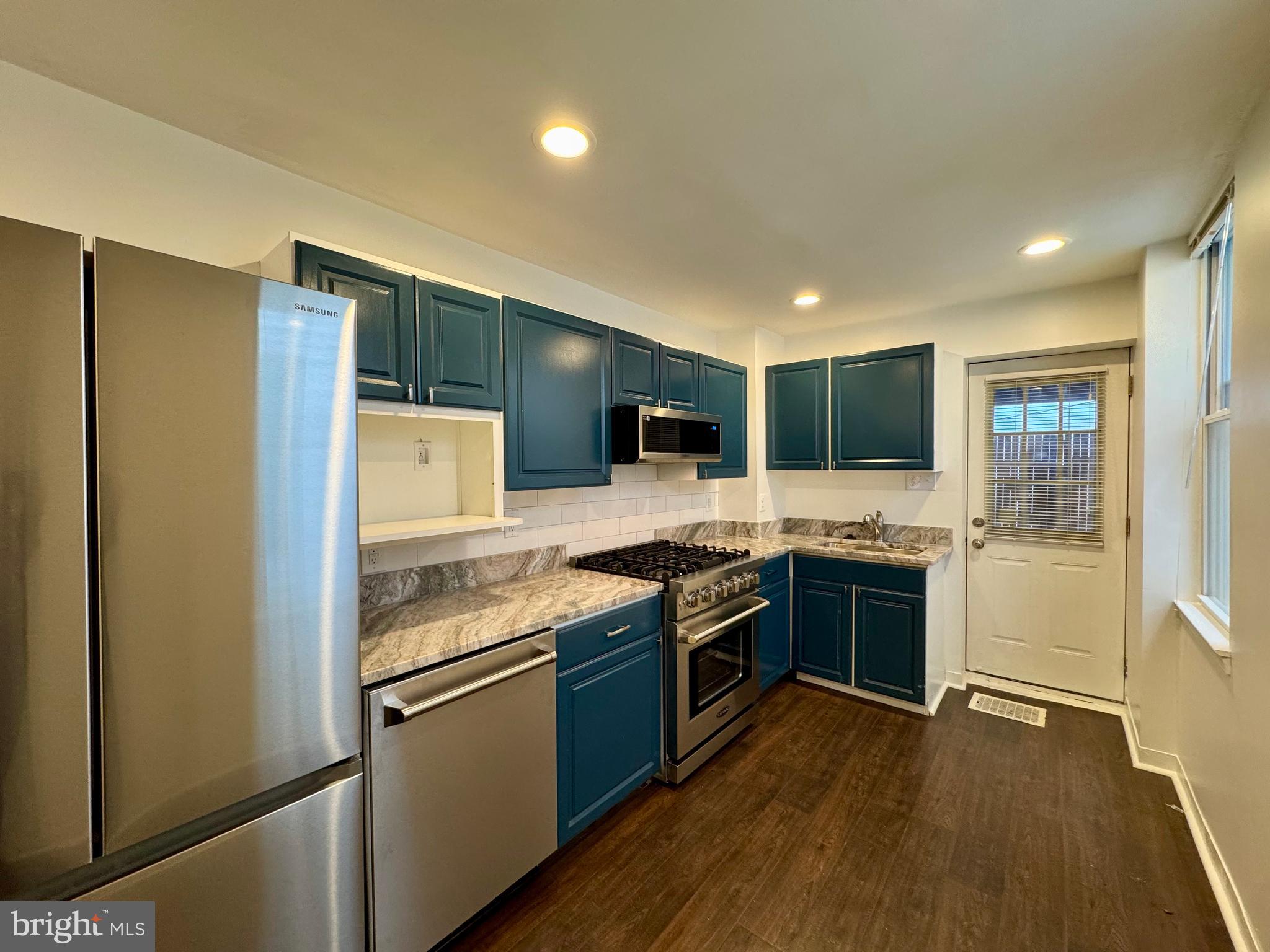 1313 Patapsco Street Baltimore, MD 21230 - Photo 7 of 20 a kitchen with stainless steel appliances granite countertop a stove and a refrigerator