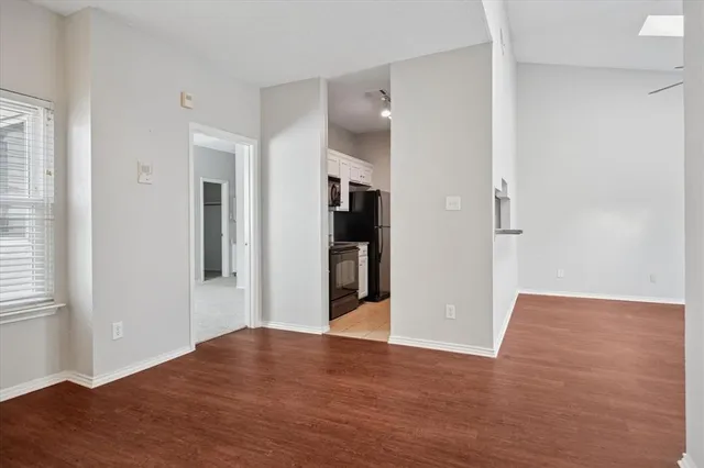 a view of a hallway with wooden floor and a bathroom