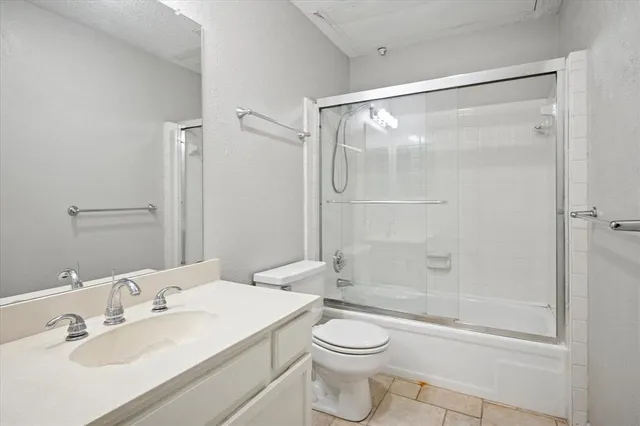 a bathroom with a bathtub shower sink vanity and toilet