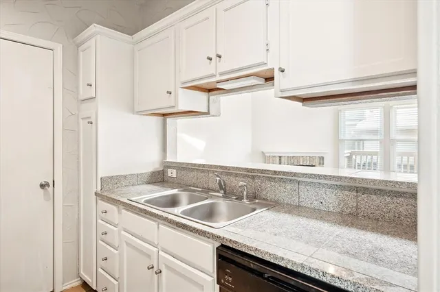 a kitchen with stainless steel appliances granite countertop a sink and a white cabinets