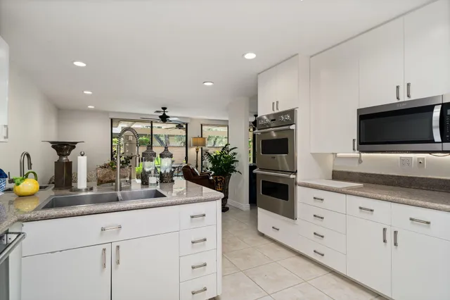 a kitchen with stainless steel appliances a stove microwave and sink