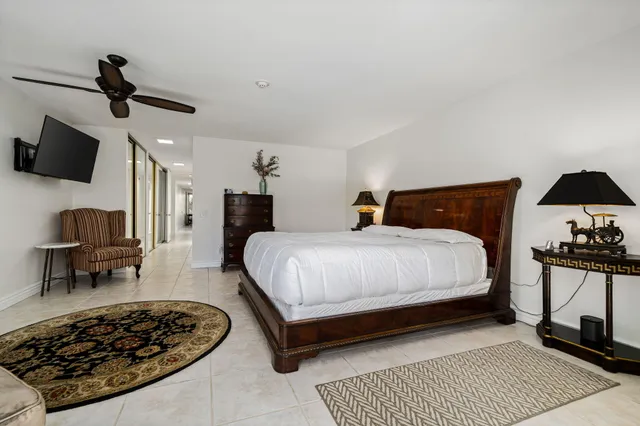 a bedroom with a bed a chair and potted plant