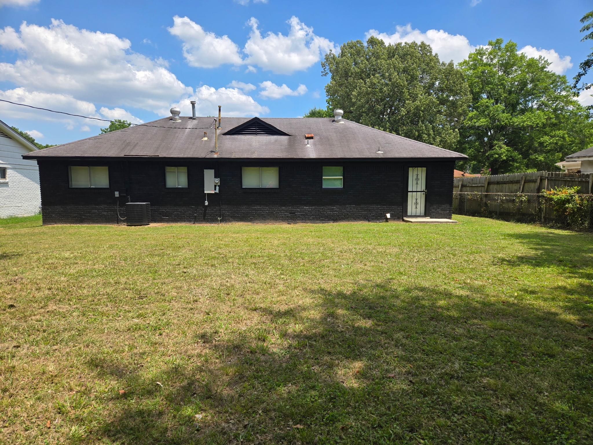 2889 Randy Cove Memphis, TN 38118 - Photo 4 of 18 Expansive grassy yard area with a dark-painted exterior and light-colored window frames