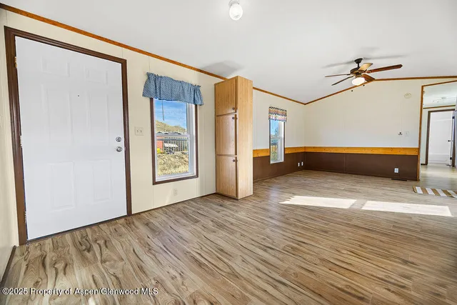 a view of an empty room with window and wooden floor