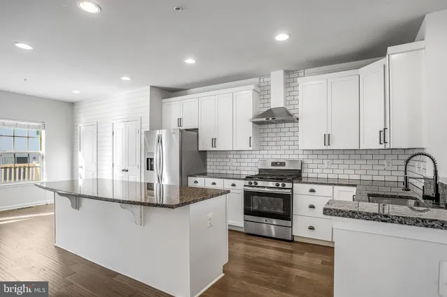 a kitchen with stainless steel appliances granite countertop a stove and a refrigerator