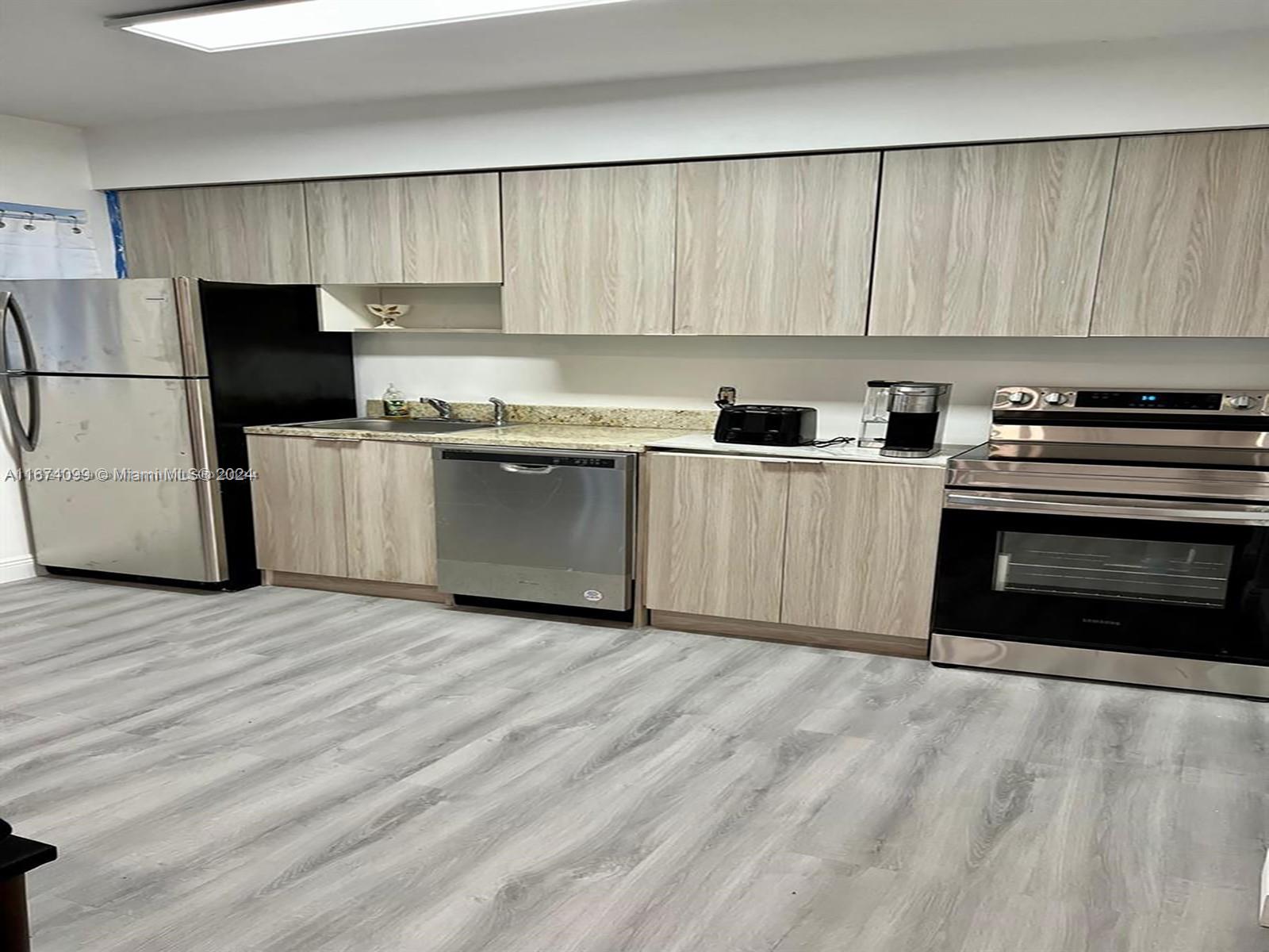 501 Northeast 70th Street, Unit 3 Miami, FL 33138 - Photo 3 of 11 a kitchen with a sink a stove and refrigerator