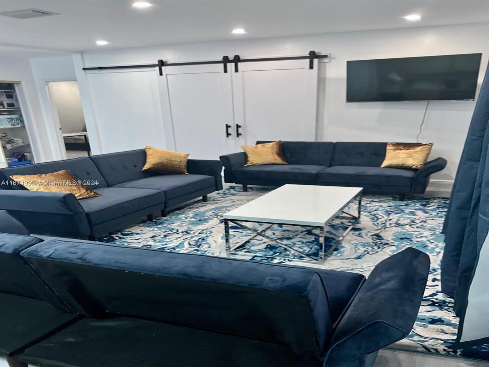 501 Northeast 70th Street, Unit 3 Miami, FL 33138 - Photo 4 of 11 a living room with furniture and a flat screen tv