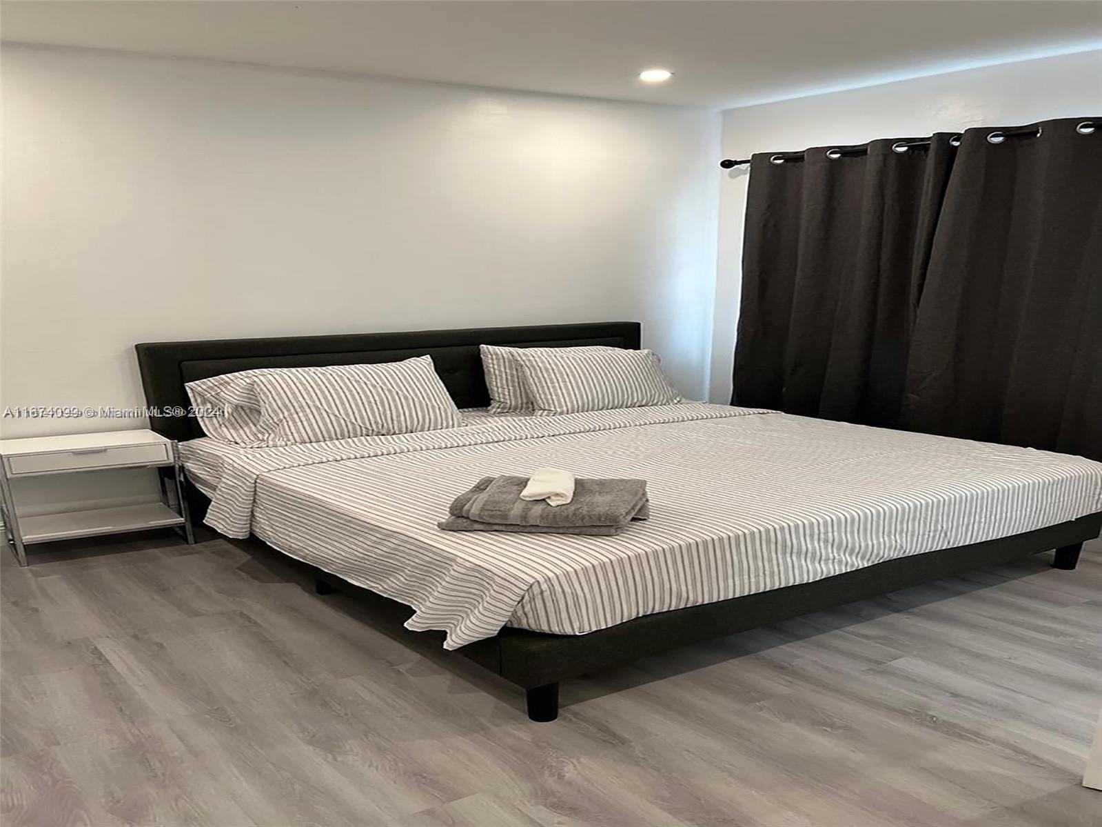 501 Northeast 70th Street, Unit 3 Miami, FL 33138 - Photo 6 of 11 a bedroom with a bed and a black countertop