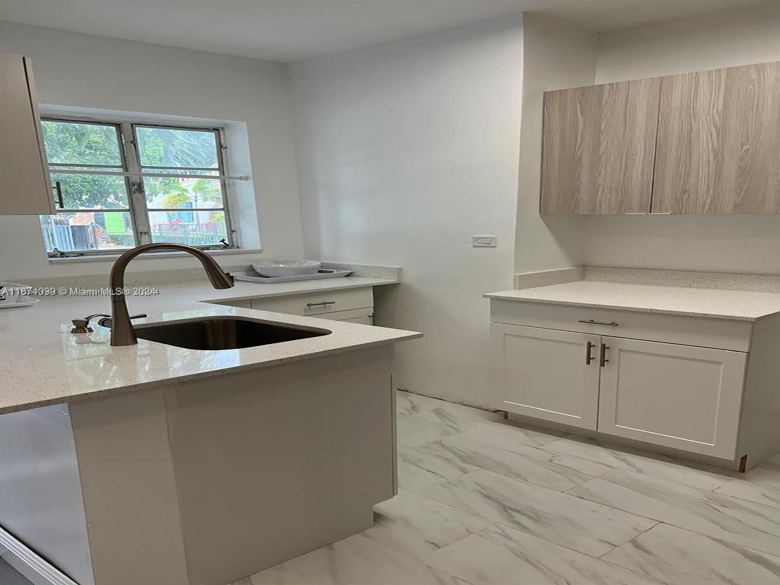 501 Northeast 70th Street, Unit 3 Miami, FL 33138 - Photo 8 of 11 a kitchen with a sink and cabinets
