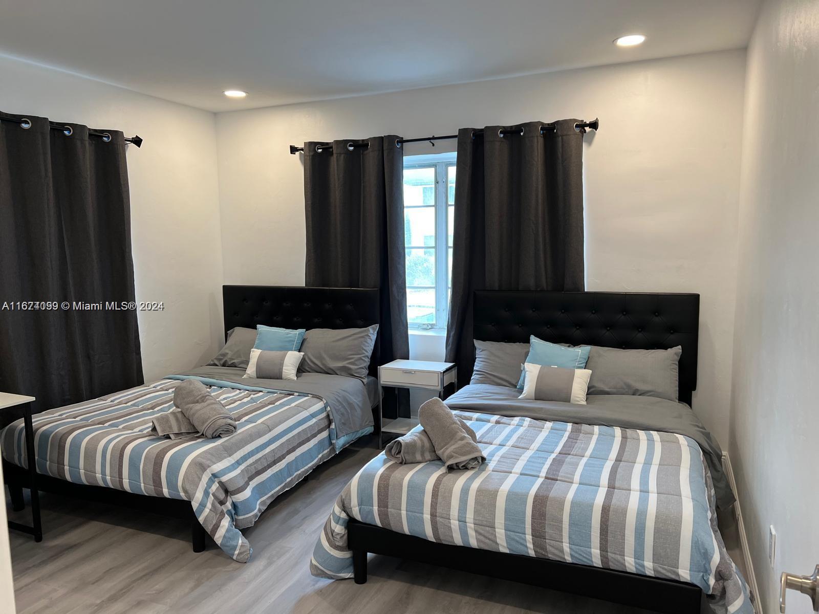 501 Northeast 70th Street, Unit 3 Miami, FL 33138 - Photo 9 of 11 a bedroom with bed and wooden floor