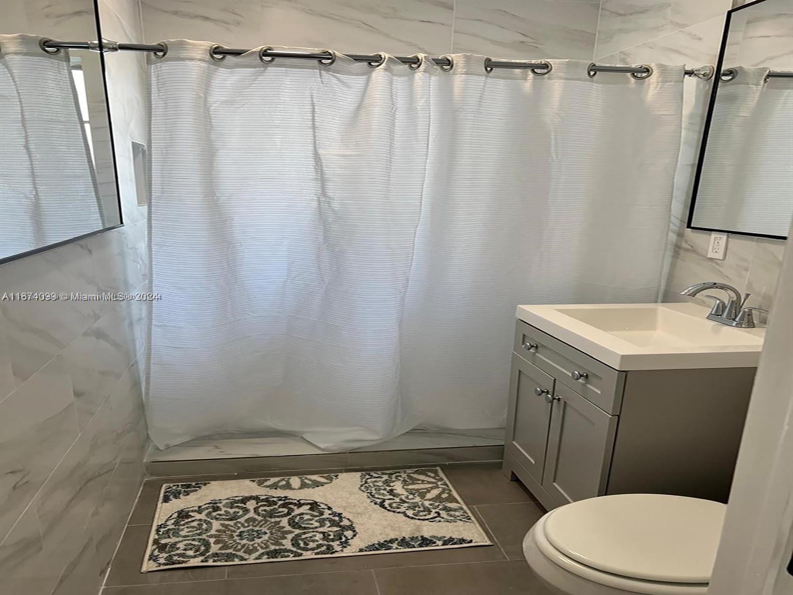 501 Northeast 70th Street, Unit 3 Miami, FL 33138 - Photo 10 of 11 a bathroom with a sink a toilet a shower and a mirror