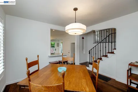 a kitchen with stainless steel appliances kitchen island granite countertop a dining table chairs and a refrigerator