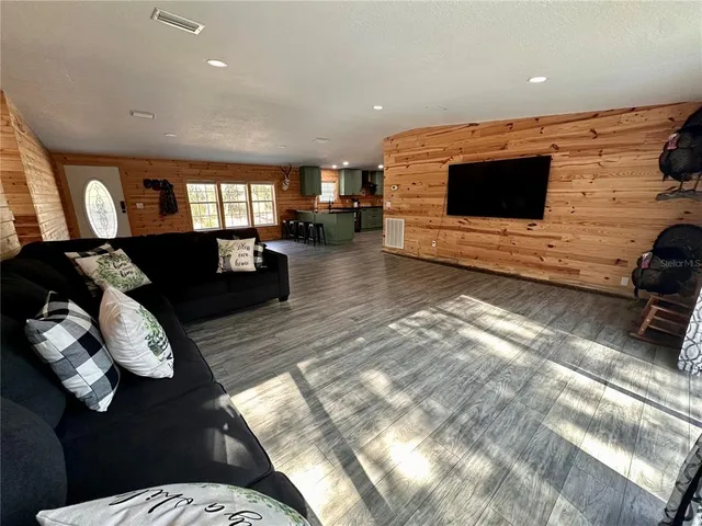 a bed sitting in a spacious bedroom next to a window