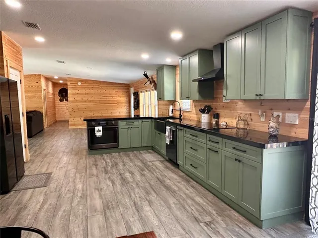 a kitchen with stainless steel appliances a refrigerator and a wooden floors