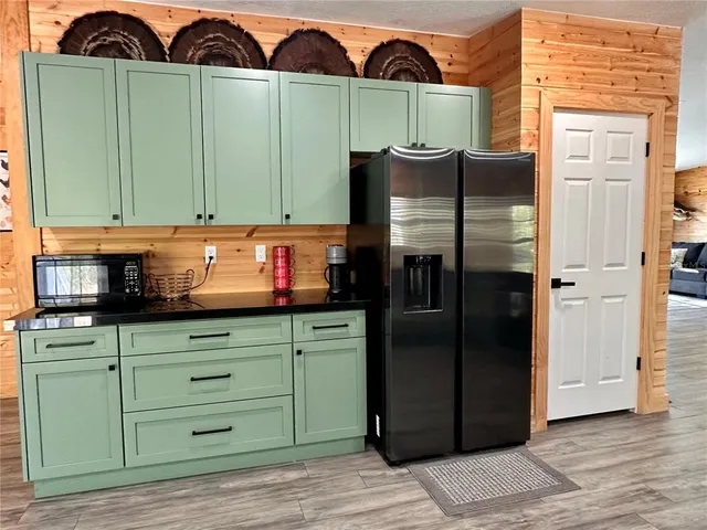 a kitchen with stainless steel appliances dining table chairs and a wooden floor