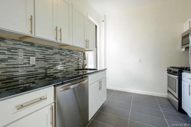 a kitchen with granite countertop a sink and a stove