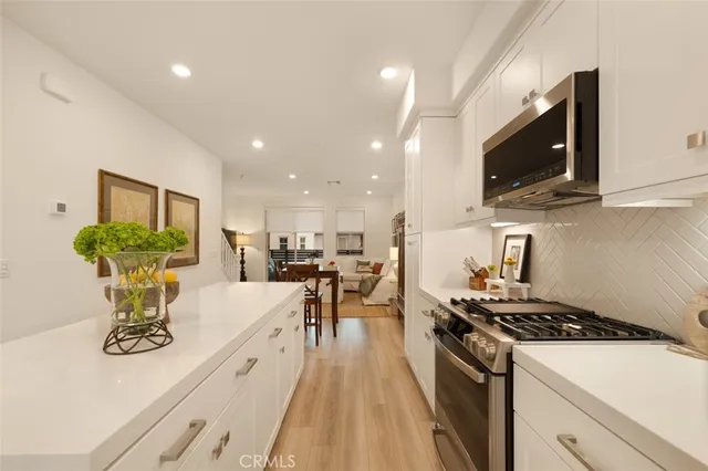 a kitchen with a sink a stove and chairs