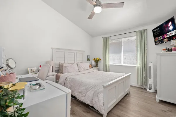 a bedroom with a bed and a flat tv screen on dresser