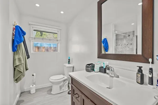 a bathroom with a sink a toilet and a large mirror