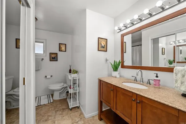 a spacious bathroom with a granite countertop sink and a mirror
