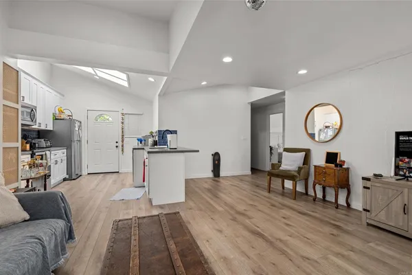 a living room with furniture kitchen view and a table