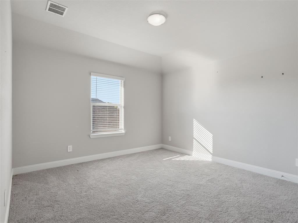 1128 Red Hawk Lane Forney, TX 75126 - Photo 26 of 37 Bright, spacious bedroom flooded with natural light through a large window with plantation shutters