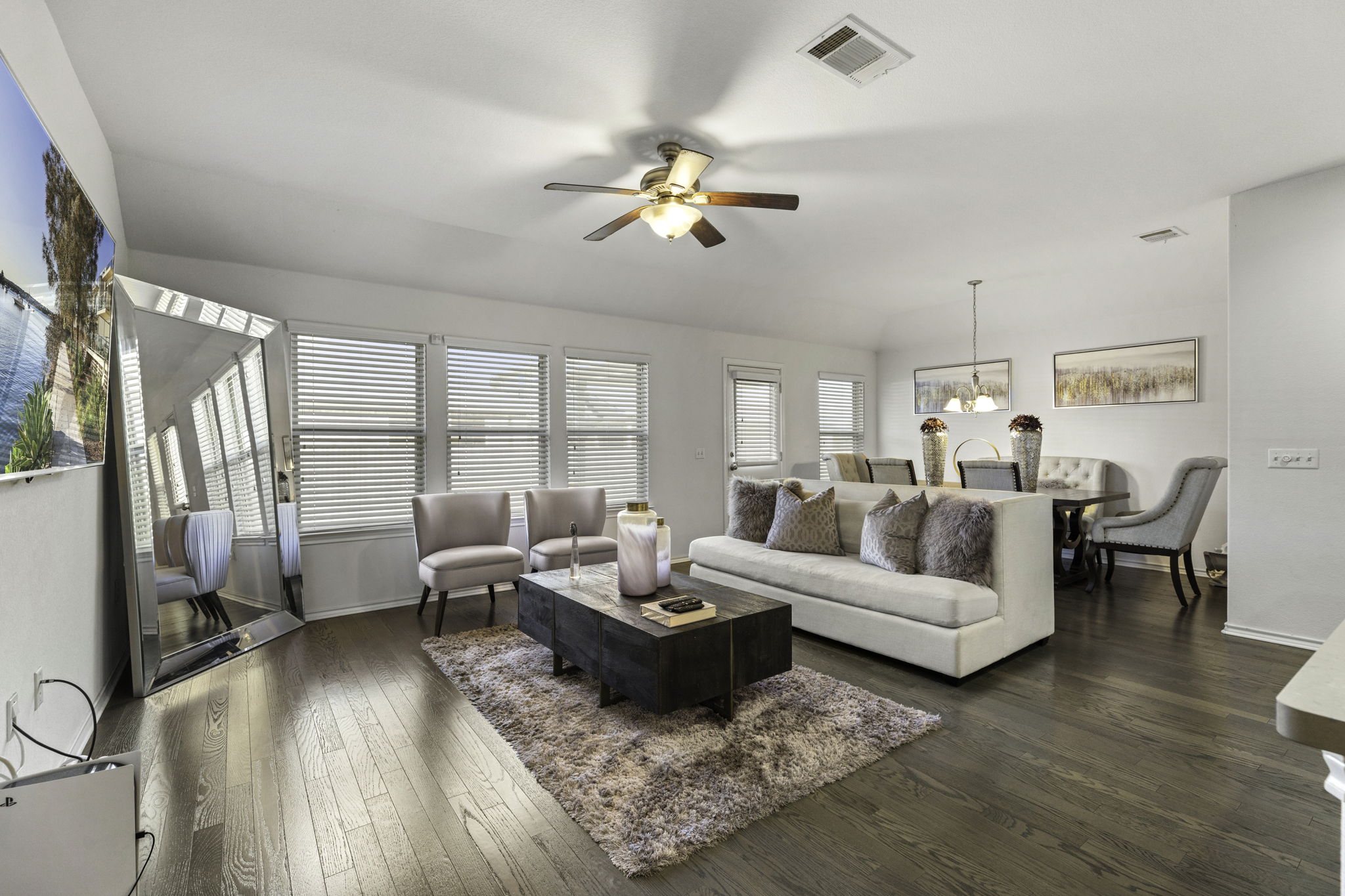 3116 Bragg Place Pflugerville, TX 78660 - Photo 7 of 29 a living room with couches a coffee table and a chandelier with wooden floor