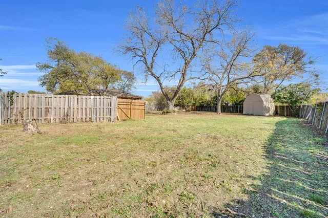 a view of a yard with wooden fence