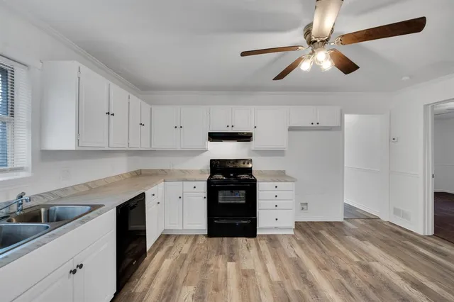 a kitchen with a stove sink and cabinets