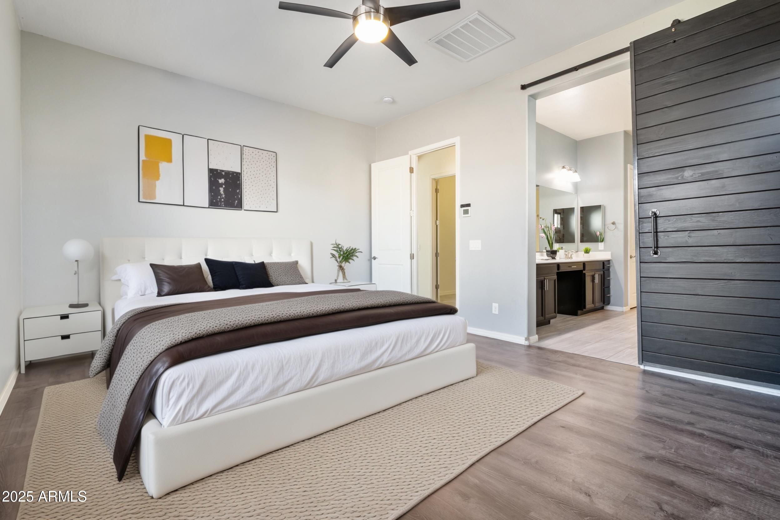 2365 North Springfield Street Buckeye, AZ 85396 - Photo 11 of 30 a bedroom with a large bed and ceiling fan
