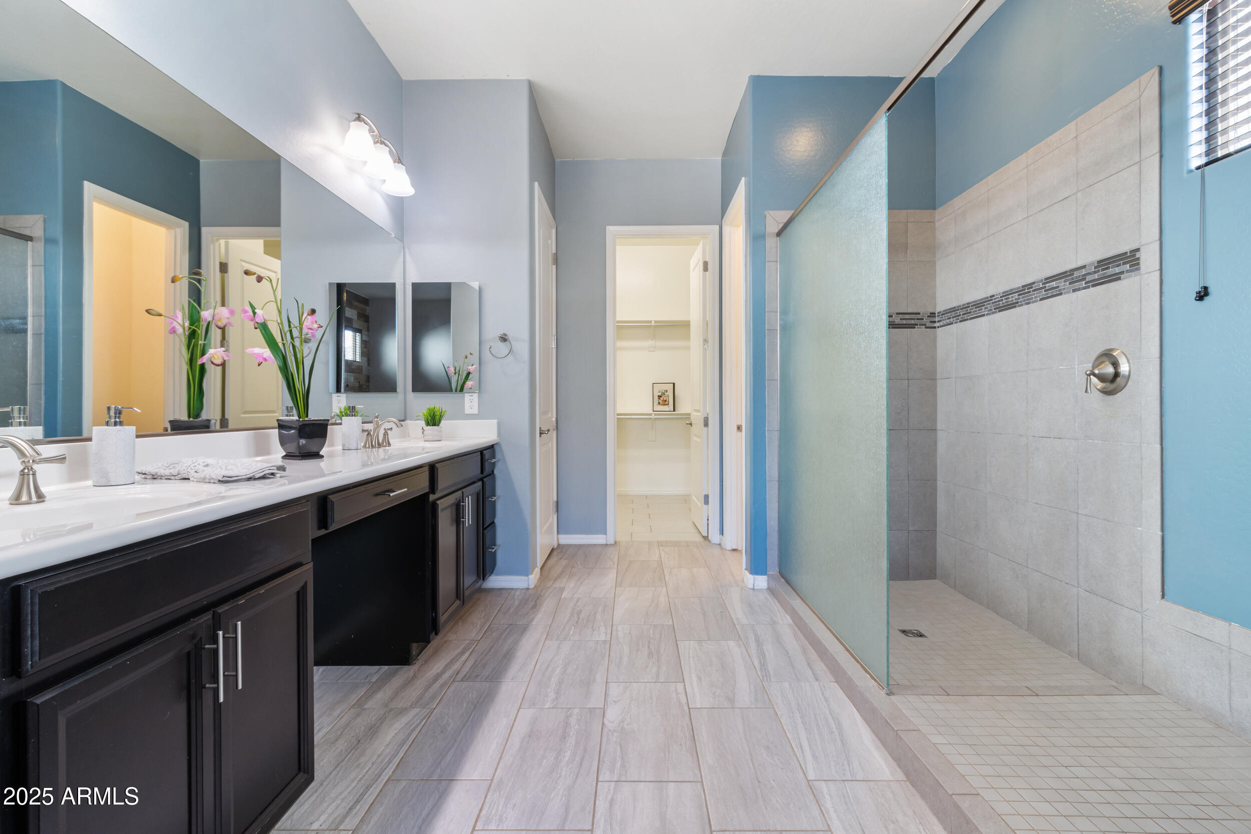 2365 North Springfield Street Buckeye, AZ 85396 - Photo 12 of 30 a bathroom with a double vanity sink a mirror and a shower