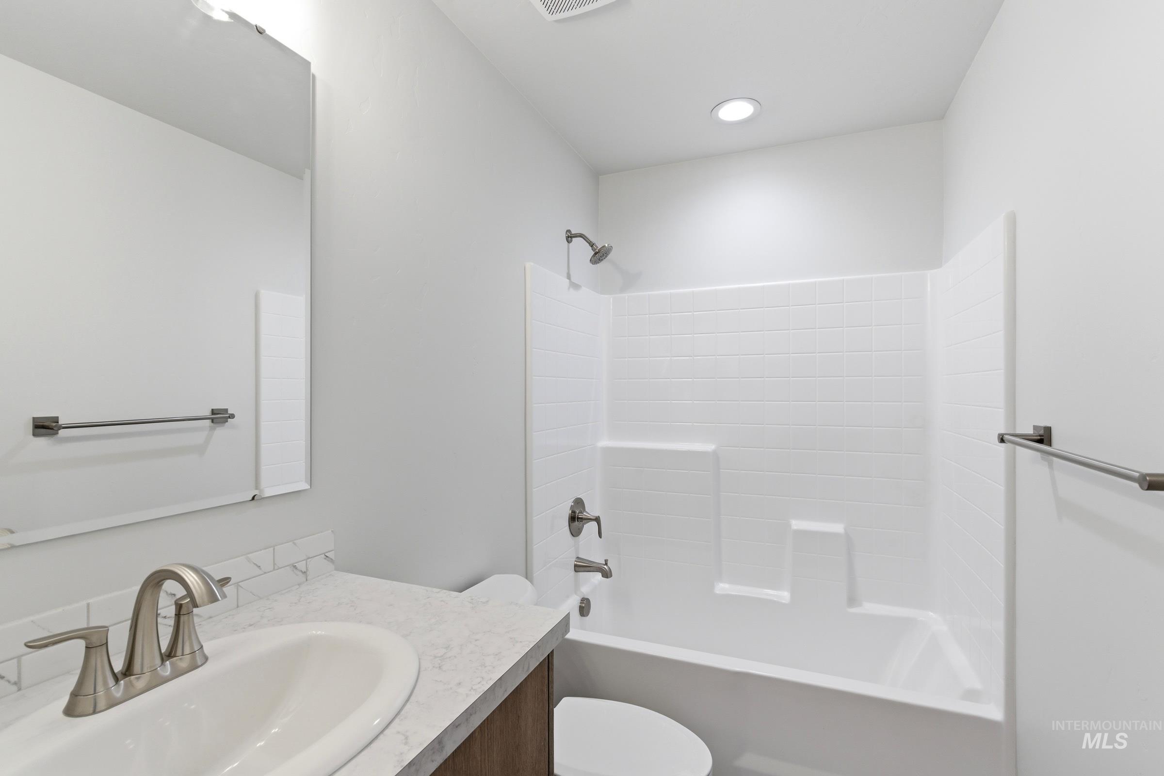 1059 West Jasper Street Meridian, ID 83642 - Photo 17 of 23 Full bathroom featuring a white subway tile tub surround, recessed lighting, and a vanity with a white countertop and undermount sink