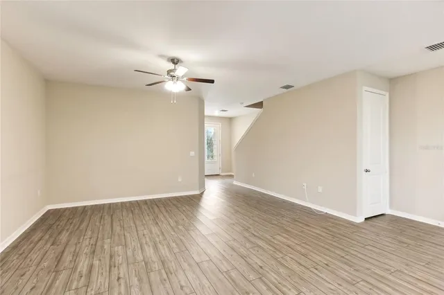 a view of an empty room with wooden floor