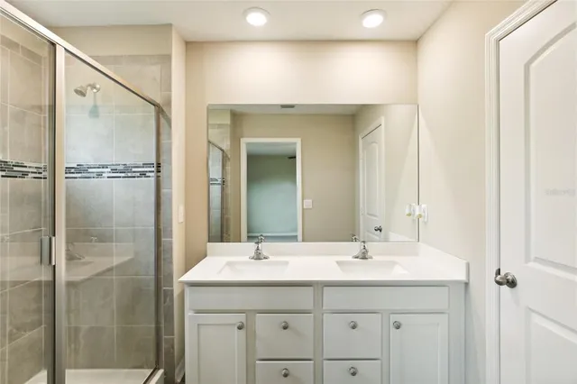 a bathroom with a shower sink and mirror