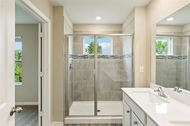 a bathroom with a shower sink and mirror