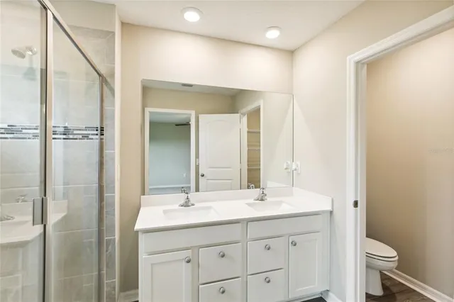 a bathroom with a sink a toilet and shower