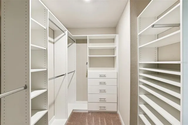 a view of walk in closet with wooden floor