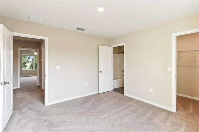 an empty room with closet and a bathroom
